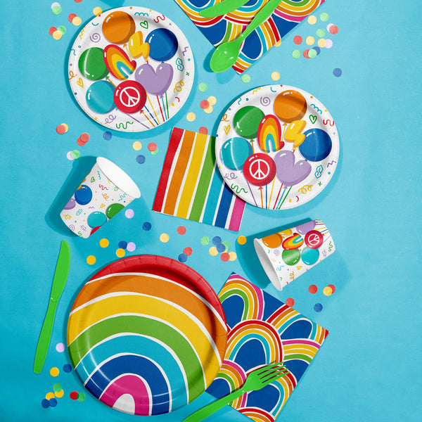 Colorful partyware set with plates, cups, napkins, and utensils on a blue background