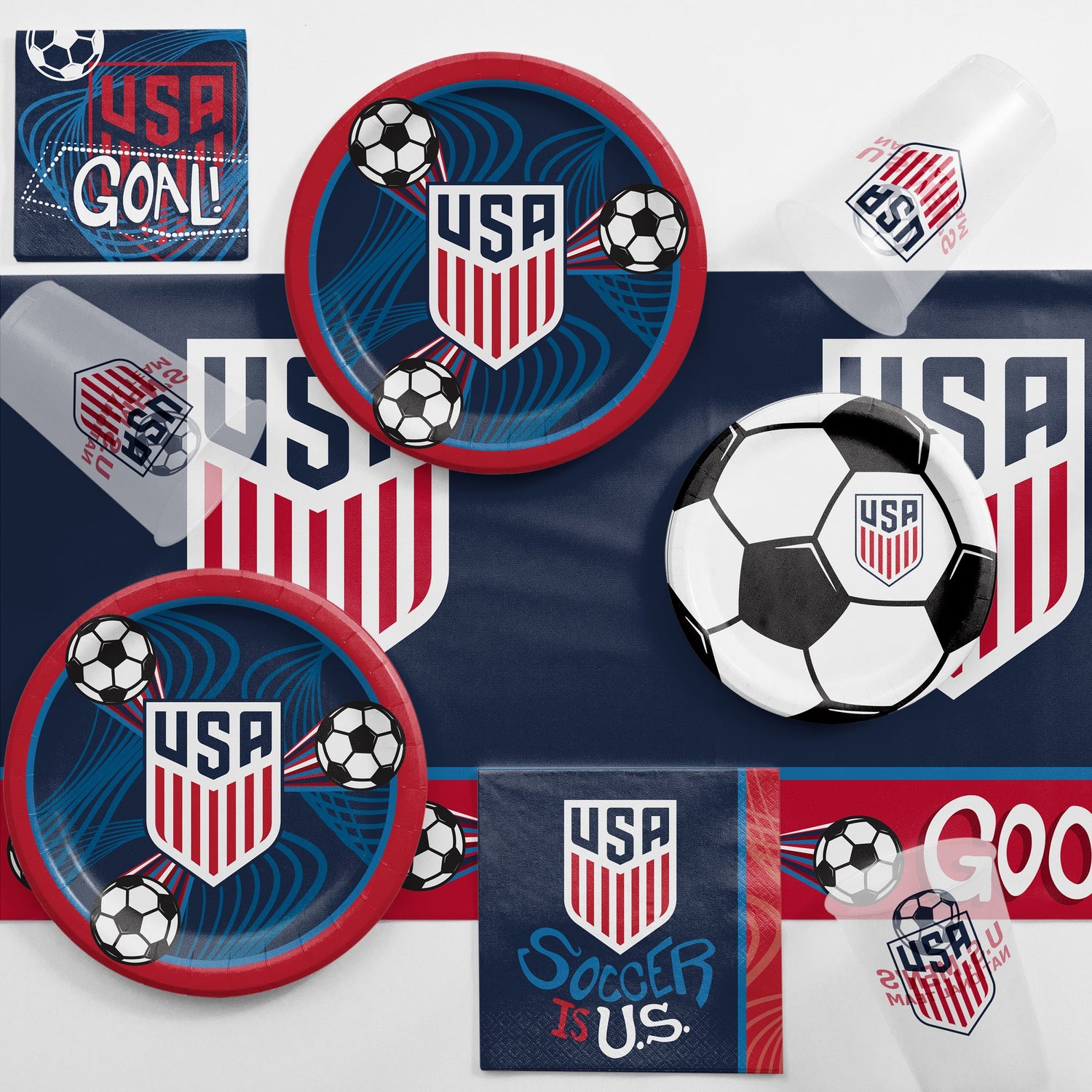 USA soccer-themed party supplies including plates, cups, and napkins on a matching tablecloth background.