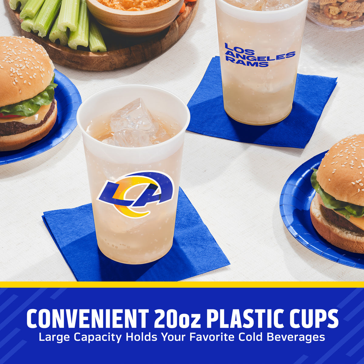 Three clear 20 oz plastic cups with Los Angeles Rams logos and 'LOS ANGELES RAMS' text, shown on blue coasters with burgers, celery, and a drink in the foreground on a table. Text at the bottom reads 'CONVENIENT 20oz PLASTIC CUPS Large Capacity Holds Your Favorite Cold Beverages'.