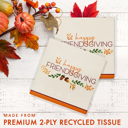 Fall Festivities Happy Friendsgiving Thanksgiving Luncheon Napkins 192 ct. Two 'Happy Friendsgiving' cards on a white wooden surface with autumn decorations.