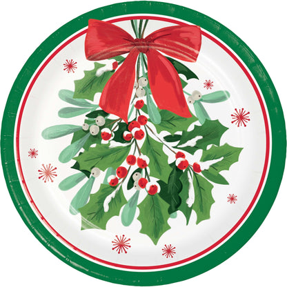 Round Christmas-themed paper plate with holly leaves, berries, and a red bow on a white background.