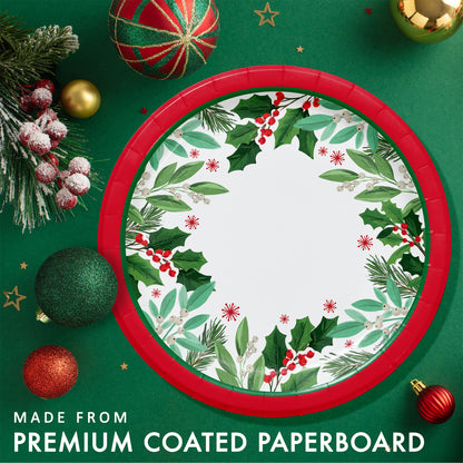 Christmas-themed paper plate with holly design and red trim. Plate shown on a green background with festive decorations.