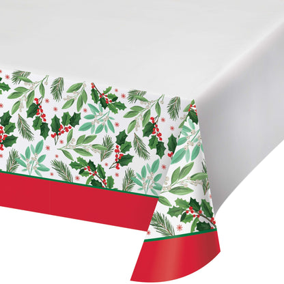Christmas-themed paper tablecloth with holly leaves and berries with red trim on a white background