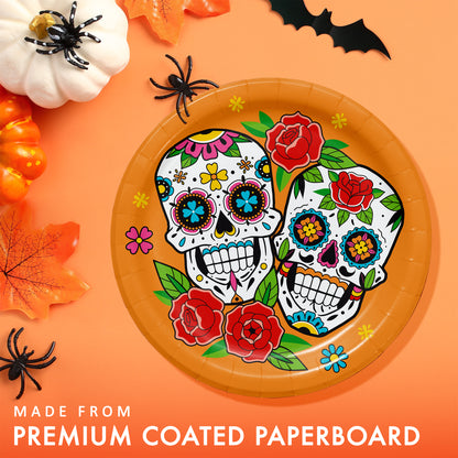 Skelebration Dessert Paper Plates 96 ct. Decorative paper plate with colorful skull design on an orange background with Halloween decorations.