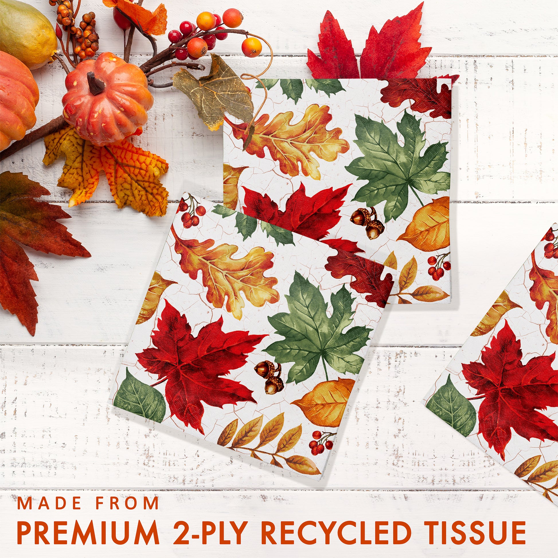 Autumn Air Beverage Napkins 192 ct. Fall-themed paper napkin with colorful leaves on a white wooden surface.