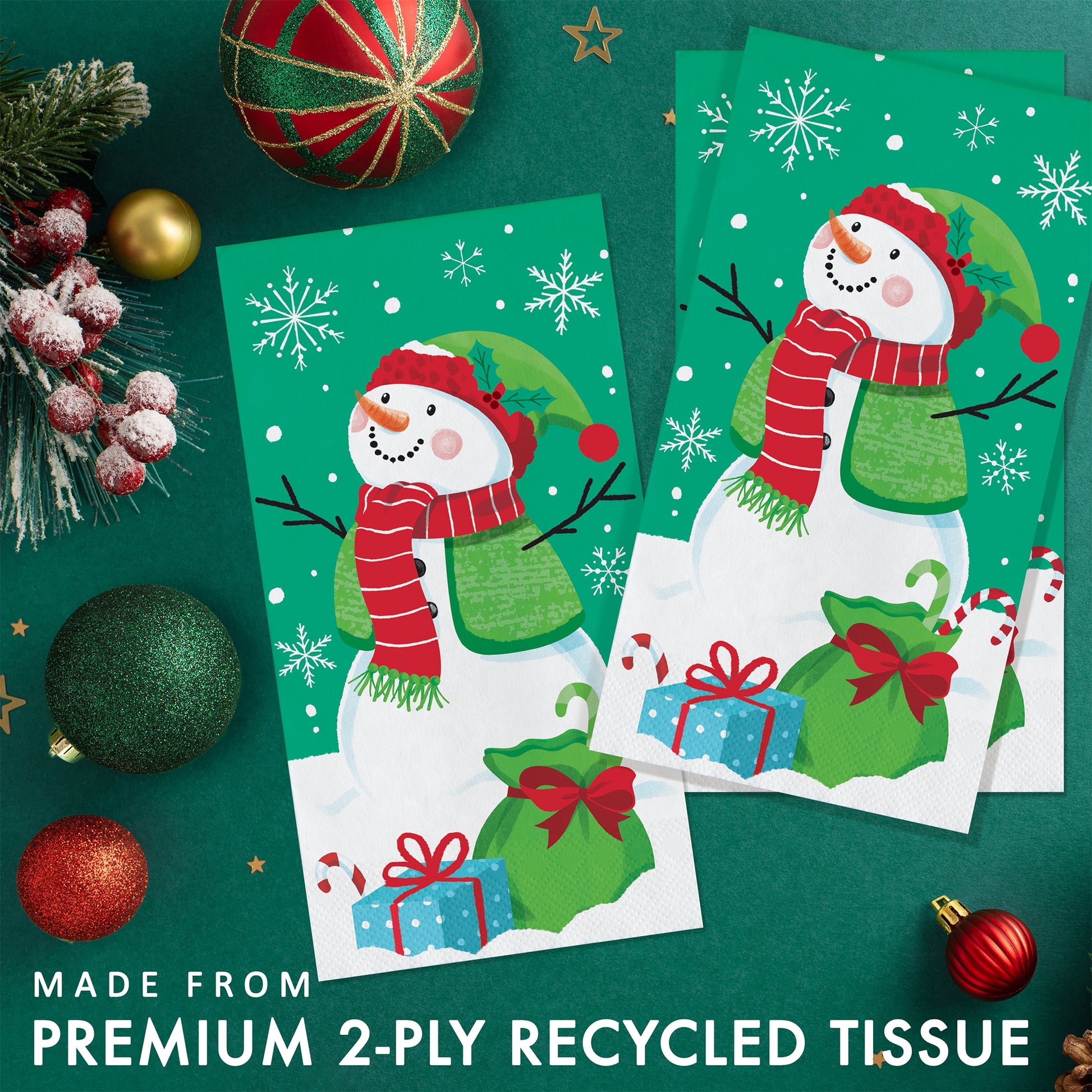 Frosty Friends Dinner Napkins 192 ct. 
Two snowman-themed paper napkins on a green background with Christmas decorations.