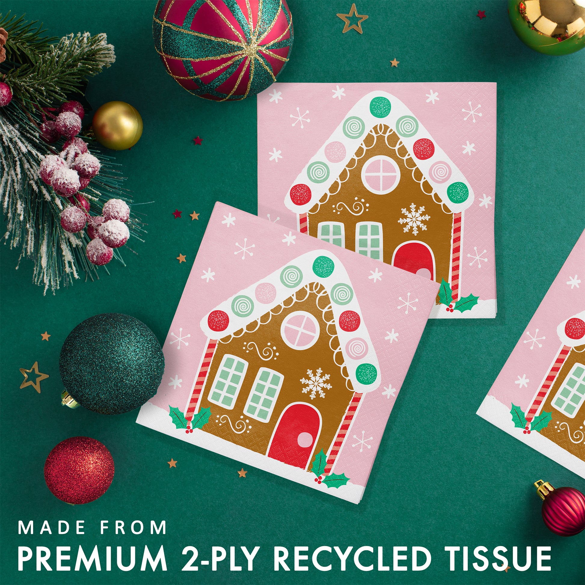Gingerbread house-themed paper napkins surrounded by Christmas decorations on a green background