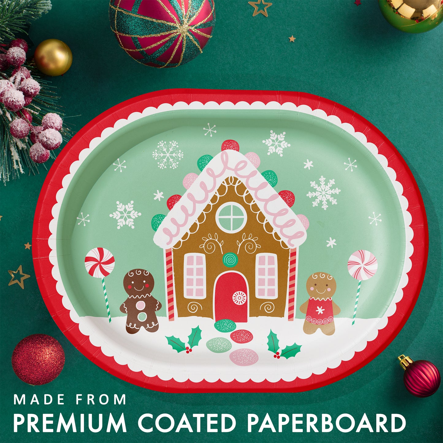 Christmas-themed oval paper plate with gingerbread house design. Plate shown on a green background with ornaments and greenery.