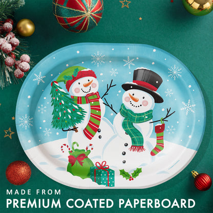 Frosty Friends Oval Dinner Paper Plates 96 ct. Oval paper plate with 2 snowmen surrounded by Christmas gifts and snowflakes. Shown on a green background with ornaments and greenery