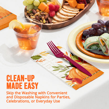 Disposable printed napkins, plastic fork, plates of food, and a glass of iced orange drink on a white tablecloth. Orange marketing text reads 'CLEAN-UP MADE EASY'.
