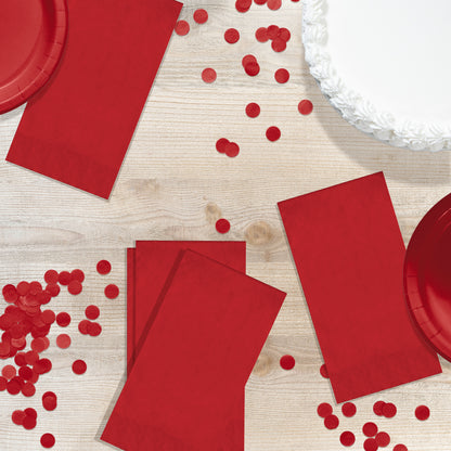 Red pin embossed guest towels on a wood table with red circle confetti