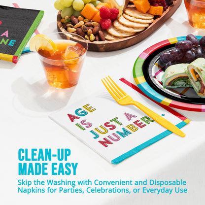 Disposable napkins with colorful text and a plate of food on a table.