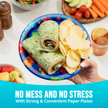 Colorful paper plate with wraps, chips, and a drink on a table with vegetables and "No Mess and No Stress" text