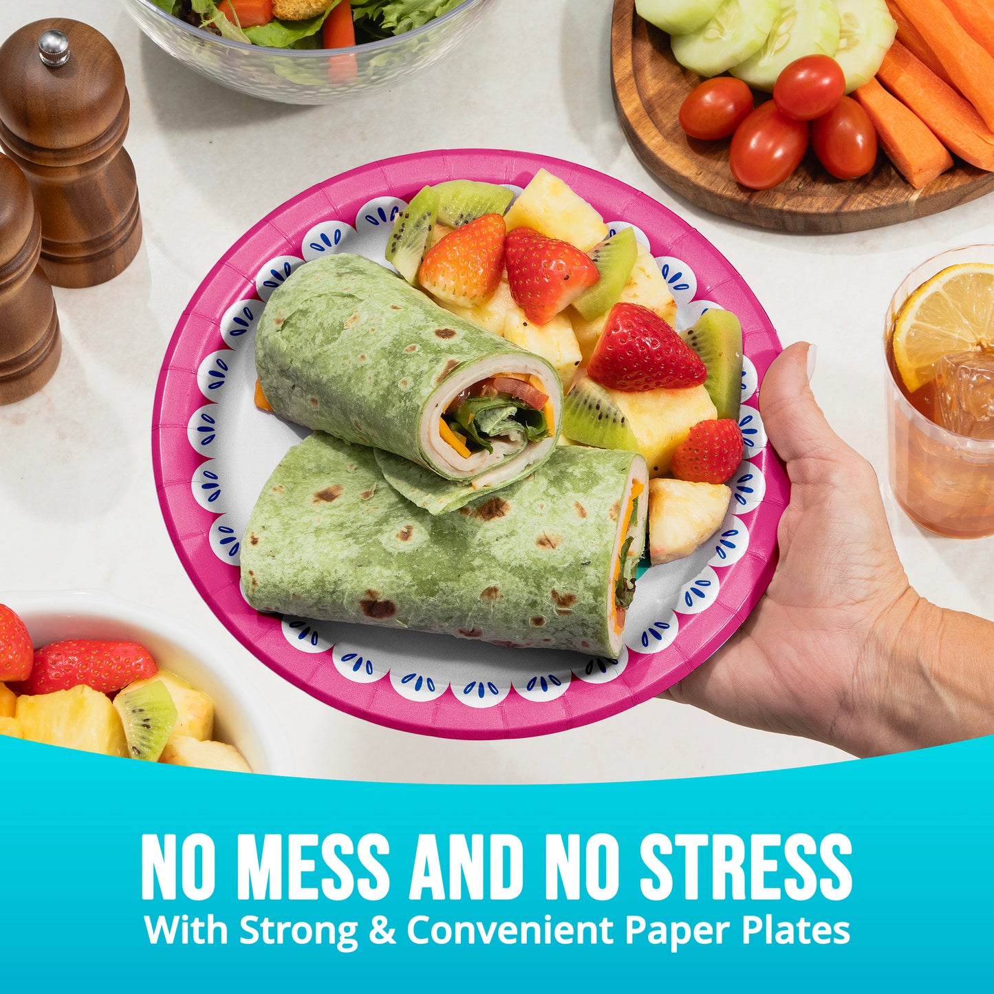 Person holding a plate with a wrap and fruit salad, surrounded by vegetables and a drink, with text 'No Mess and No Stress'.