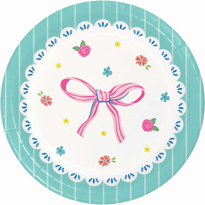 Round decorative dessert plate with a pink bow and floral patterns with teal border