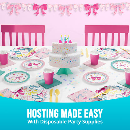 Disposable party supplies including a cake, plates, cups, and utensils on a table with pink chairs and decorative bows banner. Text "Hosting made easy"