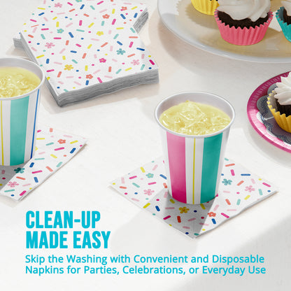 Disposable napkins with colorful designs on a table with drinks and cupcakes along with "Clean-Up Made Easy" text