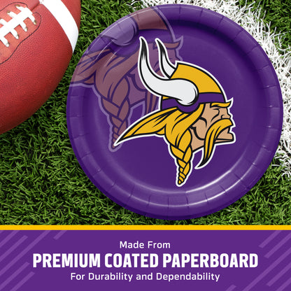 A purple paper plate featuring the Minnesota Vikings logo, shown on a grassy field with a football partially visible. A purple banner at the bottom reads 'Made From PREMIUM COATED PAPERBOARD For Durability and Dependability'.