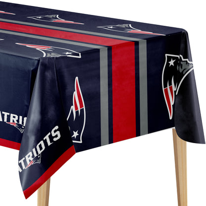 A rectangular table covered with a navy blue tablecloth featuring the New England Patriots logo, team colors, and team name. The tablecloth has vertical red and gray stripes and is shown draped over a table with wooden legs against a white background.