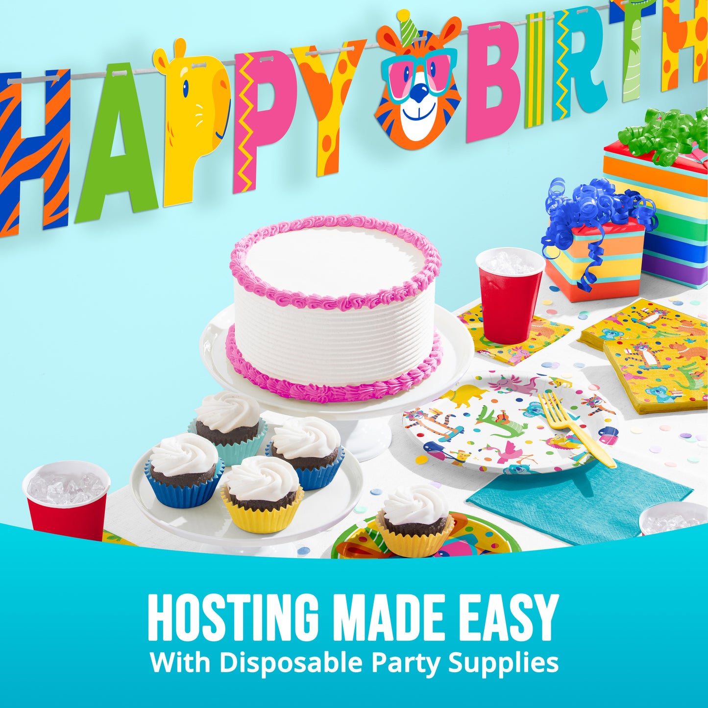 Birthday party setup with cake, cupcakes, and decorations against a blue background.