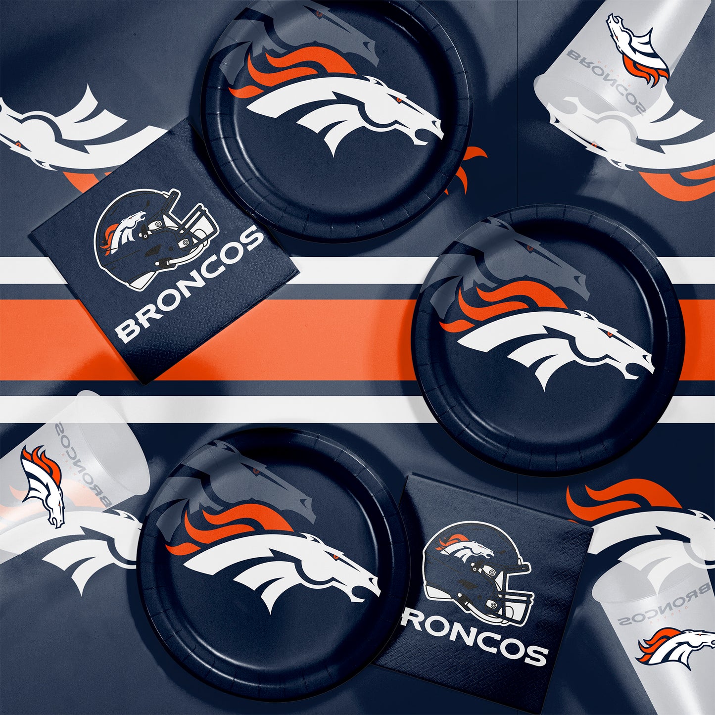 Denver Broncos-themed party supplies including plates, cups, and napkins on a dark background.