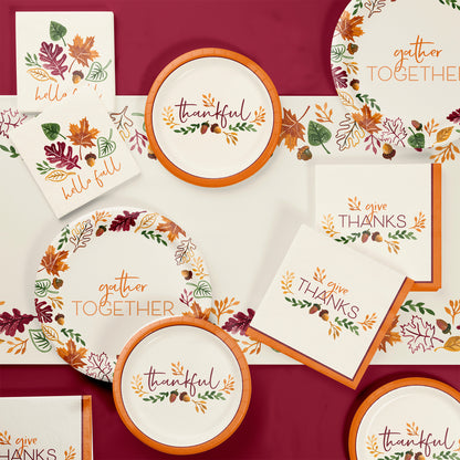 Fall Festivities Thanksgiving Paper Tablecloths 12 ct. Thanksgiving-themed tableware set with plates and napkins on a red background.