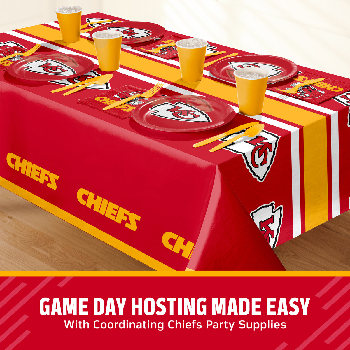 Kansas City Chiefs themed party table setting with a red tablecloth, matching plates, cups, napkins, and utensils on a table. A promotional banner at the bottom reads 'GAME DAY HOSTING MADE EASY With Coordinating Chiefs Party Supplies'.
