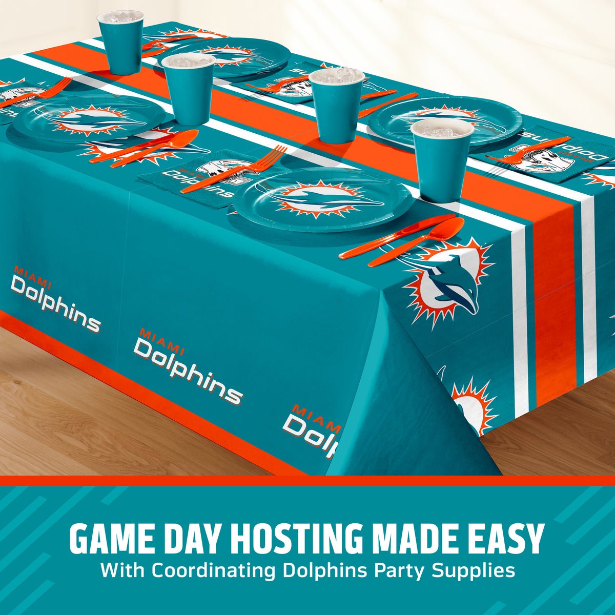 Miami Dolphins themed party table setting with a printed tablecloth, matching plates, cups, and utensils, shown on a table with a promotional banner at the bottom that says "Game Day Hosting Made Easy".