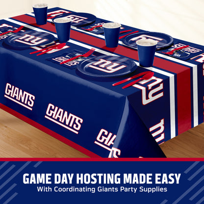 New York Giants themed party table setting with a printed tablecloth, matching plates, cups, and utensils, shown on a table with a promotional banner at the bottom that says "Game Day Hosting Made Easy".