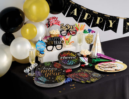 New Year's Eve party setup with balloons, cake, and decorations on a table.