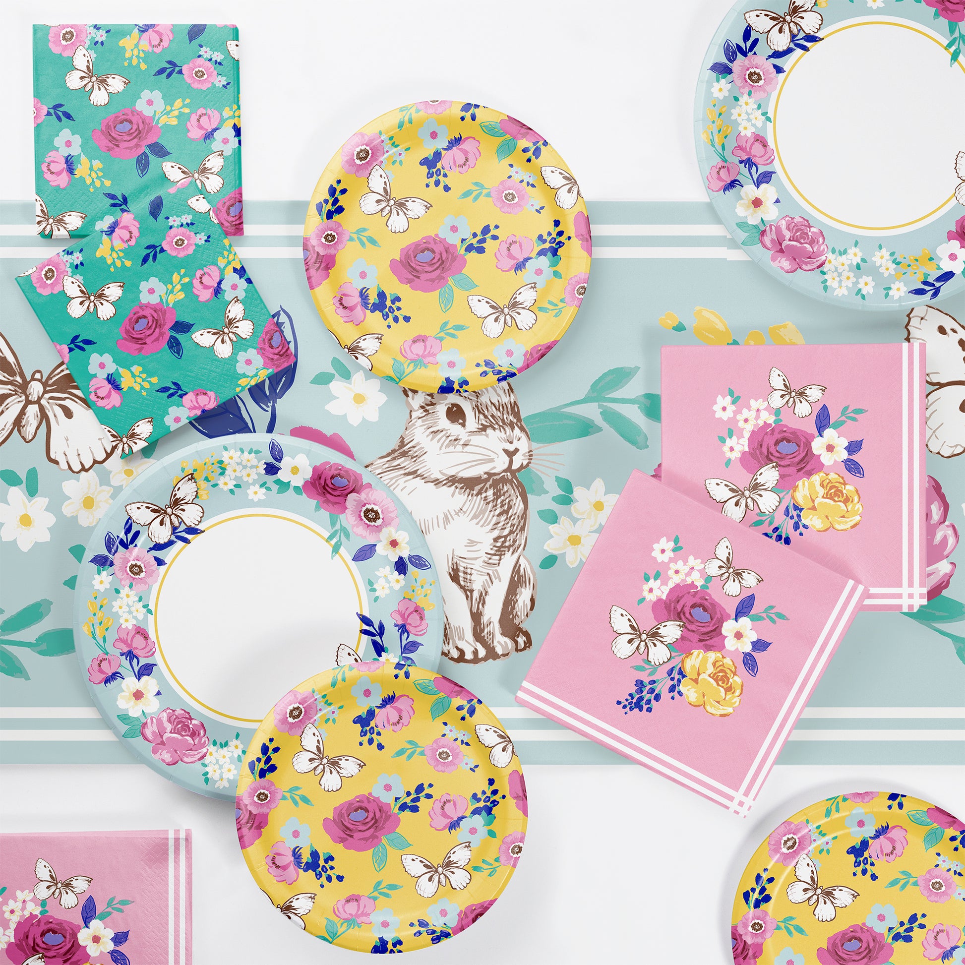 Floral and butterfly-themed party supplies including plates, napkins, and cups on a light blue background.