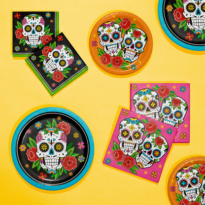 Skelebration Dinner Paper Plates 96 ct. Decorative plates and napkins with colorful skull designs on a yellow background