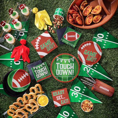 Football Drink Holder 12 ct. Game day-themed tableware, snacks and decorations on a grass-like surface